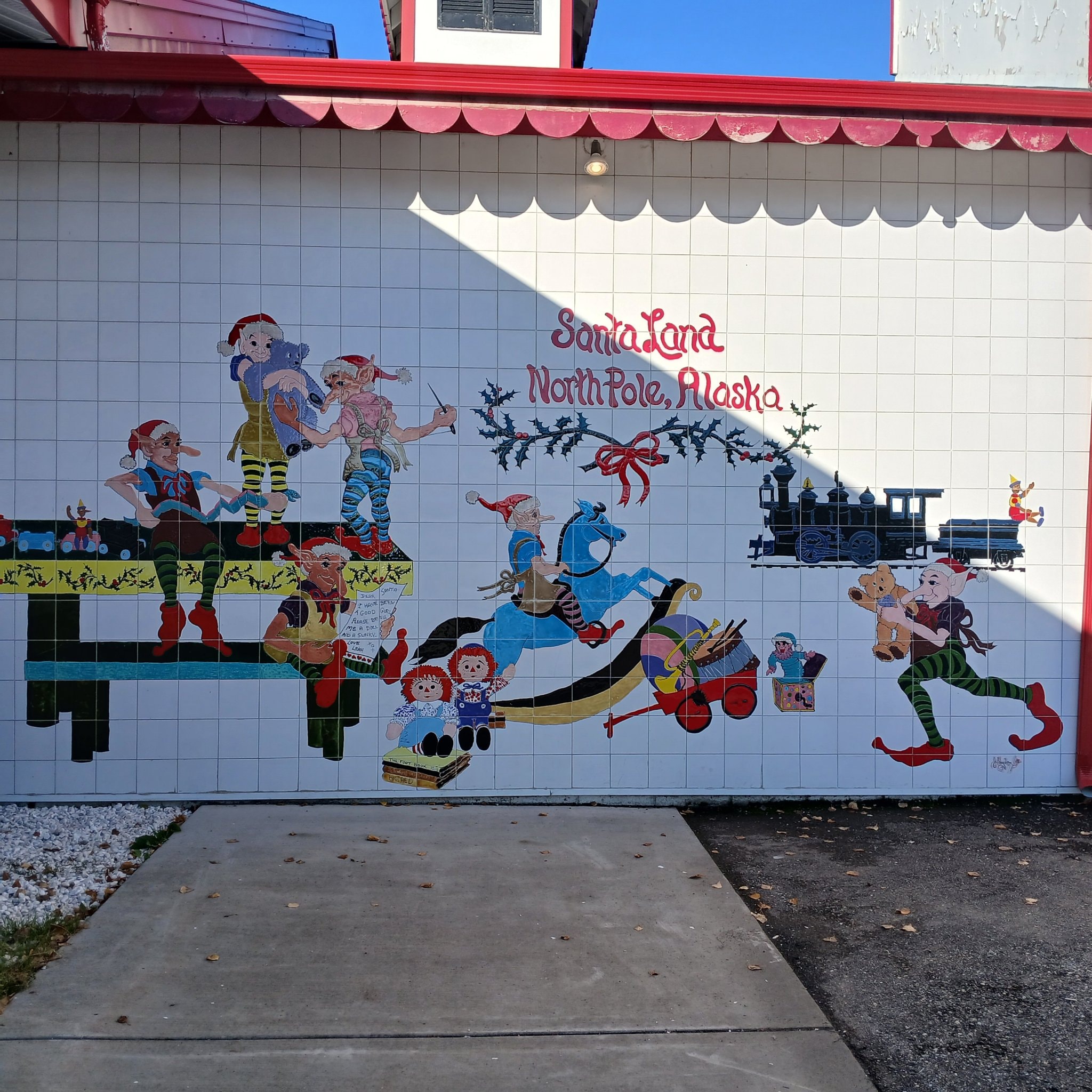 SantaLand North Pole Alaska elf mural with elves, toys, and a train