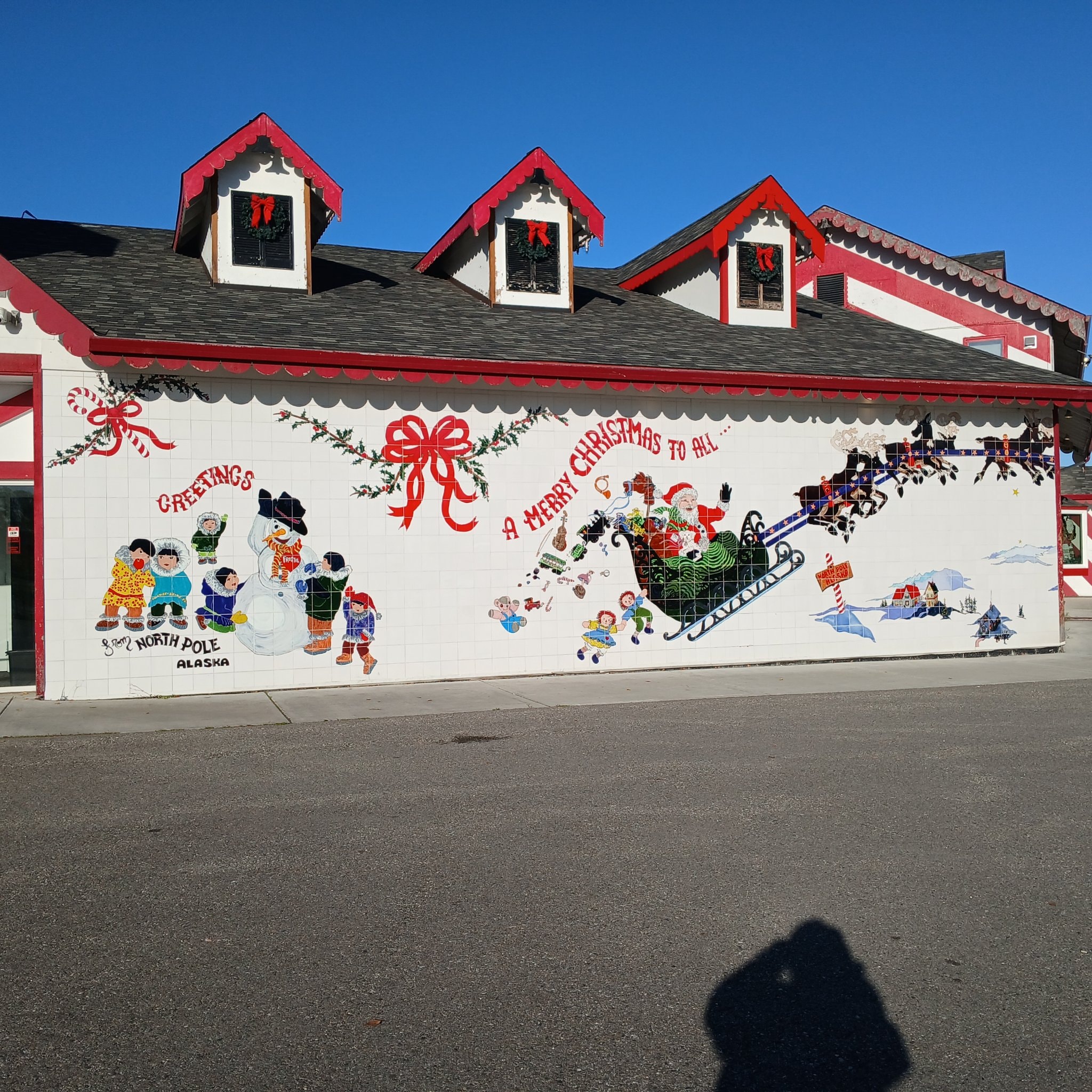Greetings from North Pole Alaska mural wall with Santa in his sleigh and reindeer
