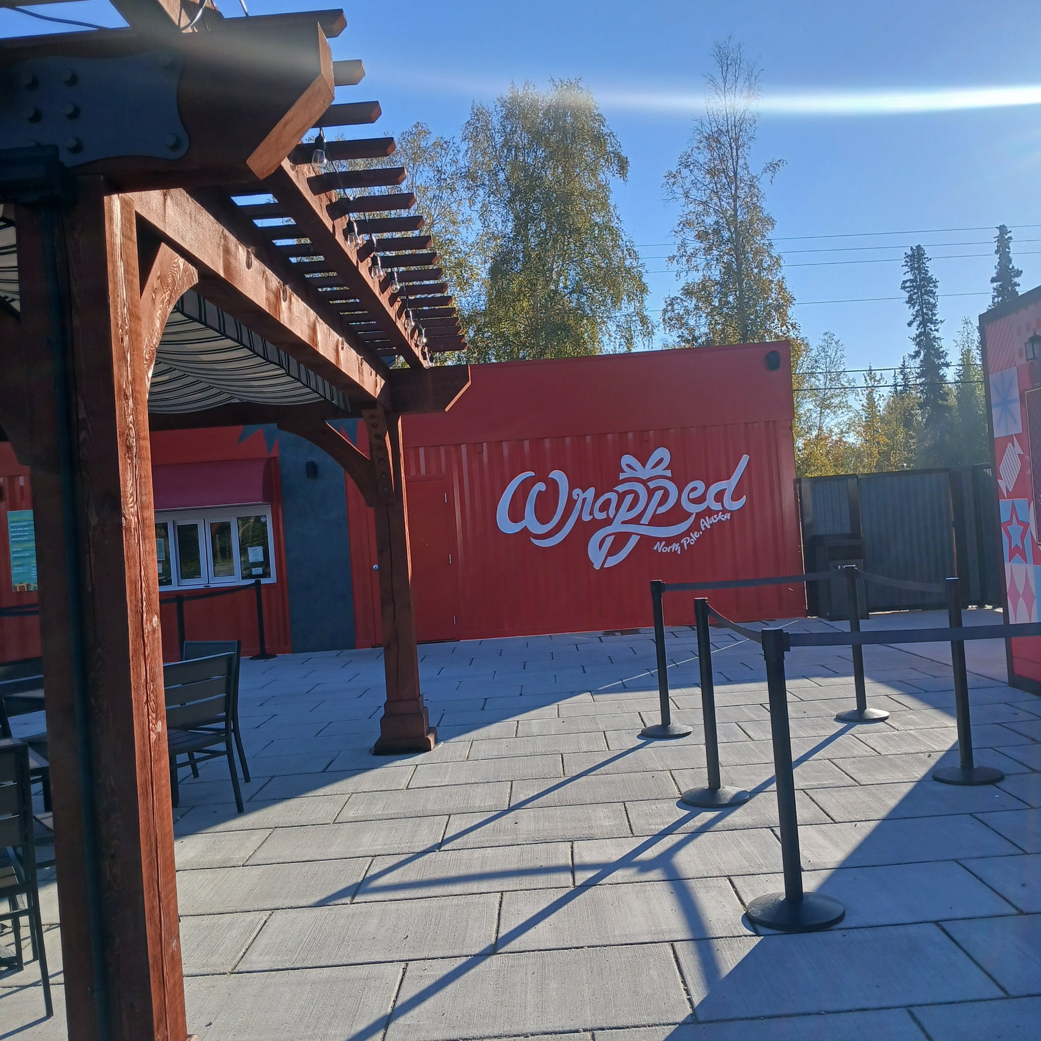 Wrapped North Pole Alaska outdoor area with red shipping container and pergola