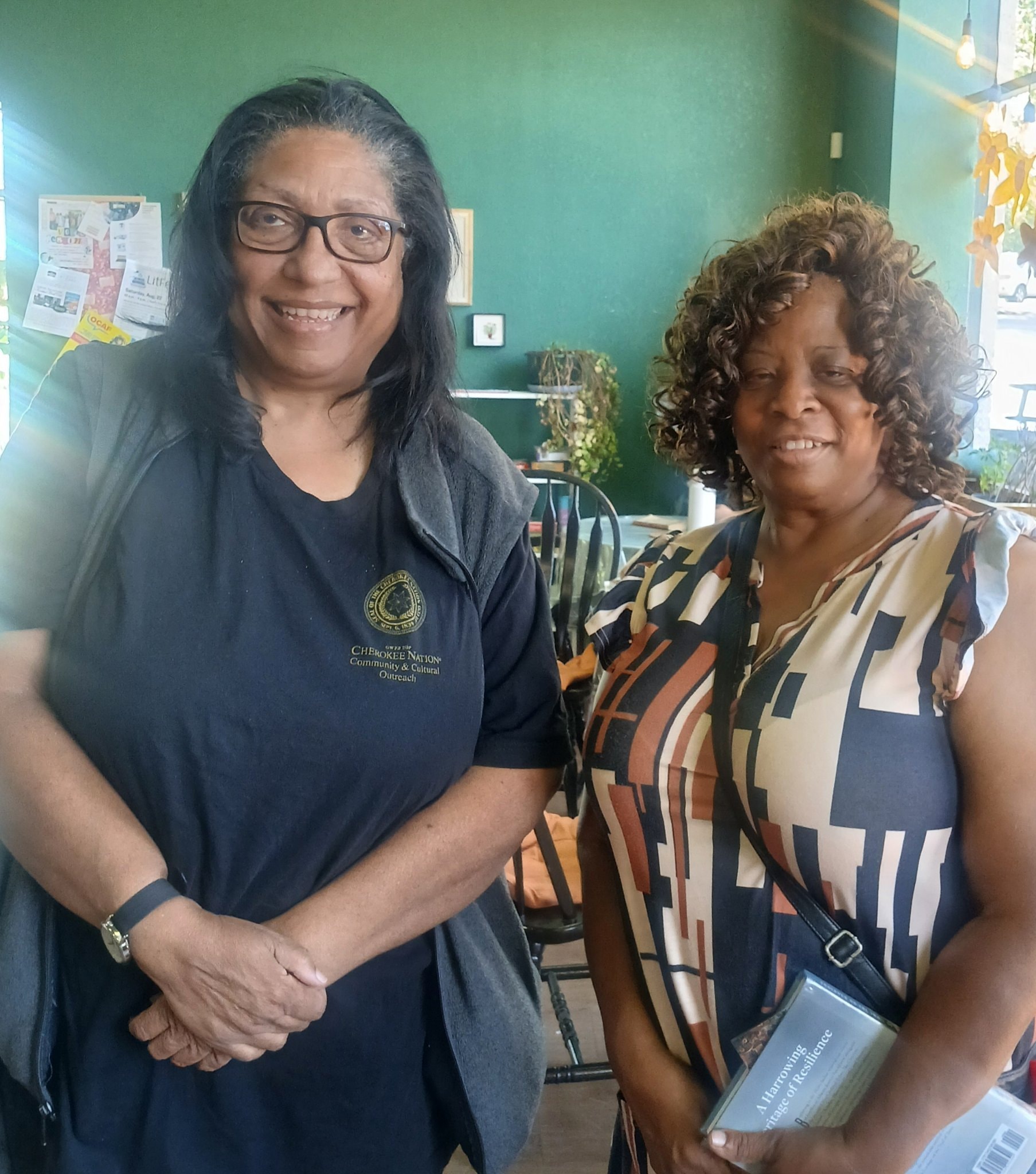 Two women, one in Cherokee Nation shirt, at community event
