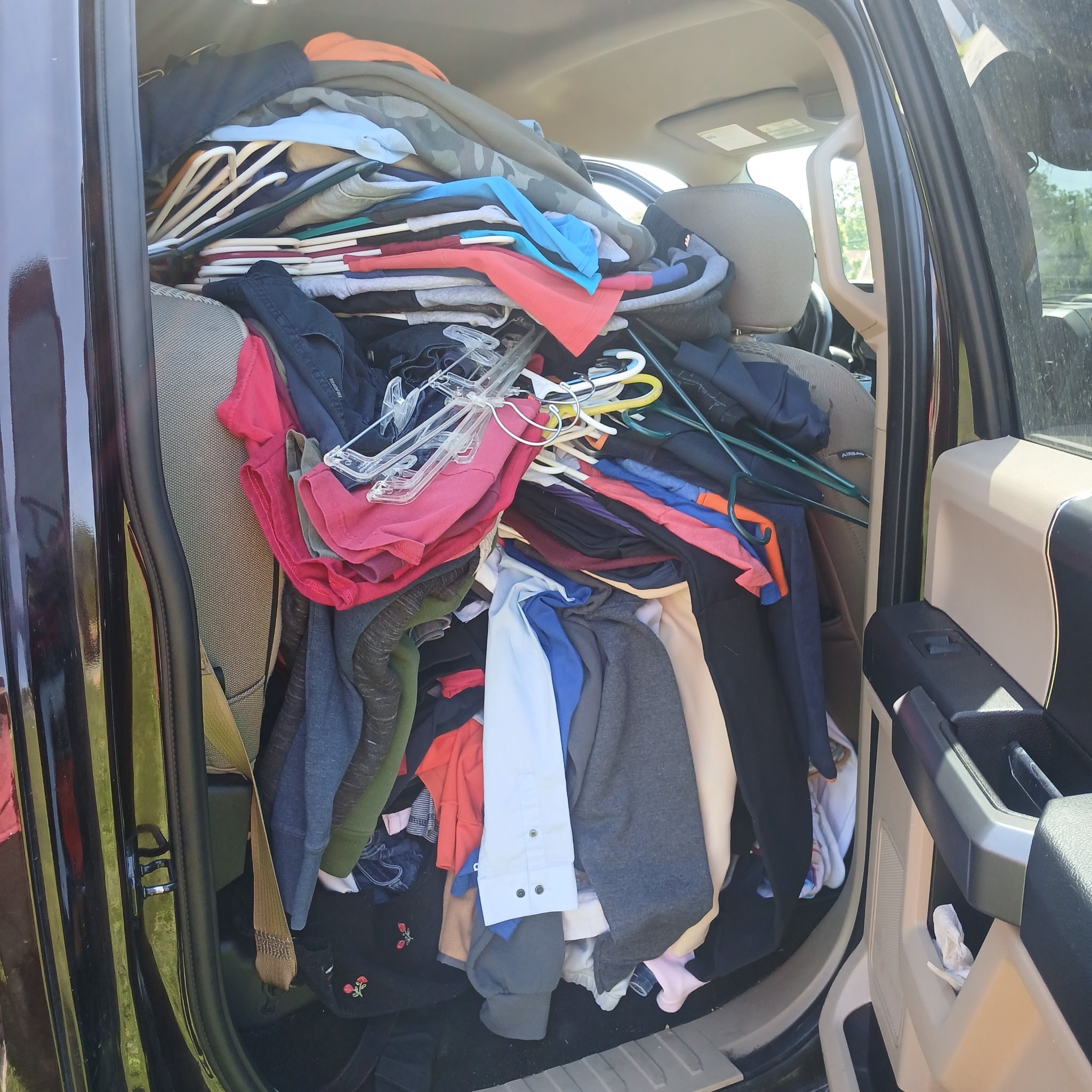 Vehicle packed full of donated clothing and hangers for community distribution